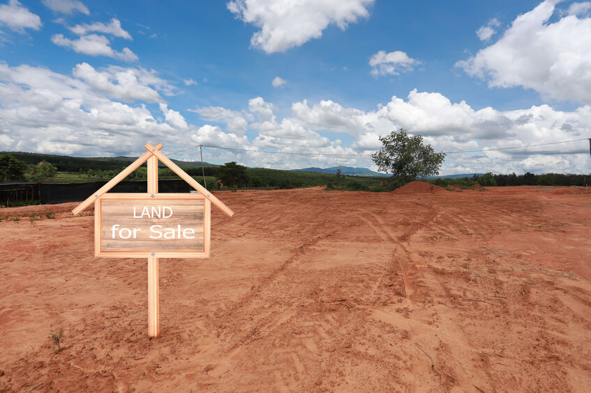 Empty land with limitless possibilities with a for sale sign
