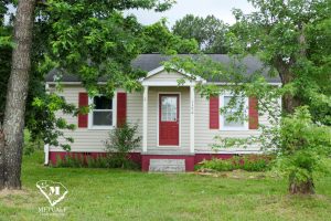Charming two-bedroom, one-bath home in Inman with a welcoming red door and lush greenery surrounding the property. Charming two-bedroom, one-bath home in Inman with a welcoming red door and lush greenery surrounding the property.