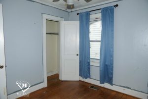 Cozy bedroom featuring blue walls, a window with curtains, and a closet door in a 2 bed, 1 bath home in Inman. Cozy bedroom featuring blue walls, a window with curtains, and a closet door in a 2 bed, 1 bath home in Inman.