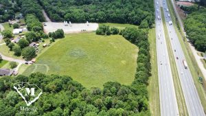 Aerial view of a multi-use property adjacent to Interstate 85, featuring open land and surrounding greenery. Aerial view of a multi-use property adjacent to Interstate 85, featuring open land and surrounding greenery.
