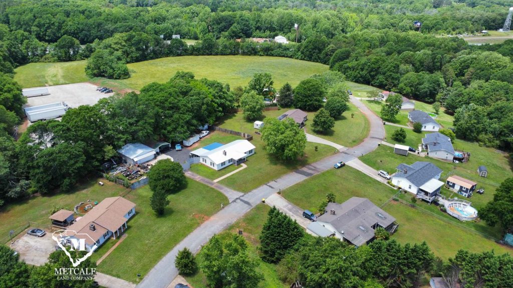 Aerial view of a multi-use property with residential homes and open land near Interstate 85, showcasing potential development.