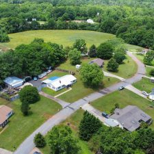 Aerial view of a multi-use property with residential homes and open land near Interstate 85, showcasing potential development.