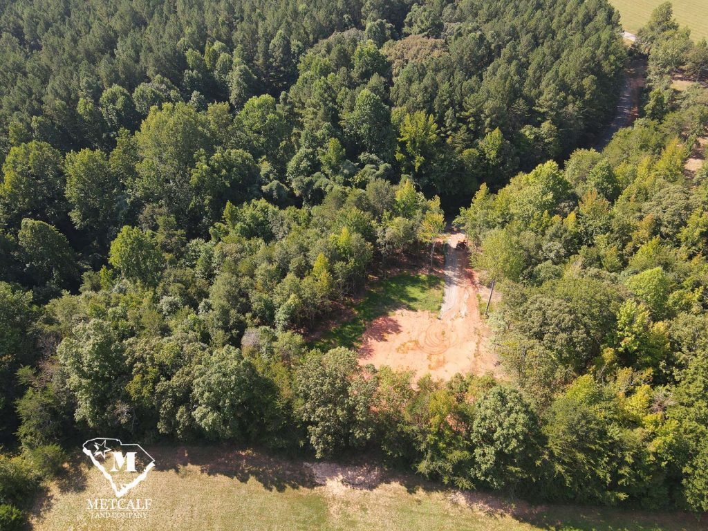 Aerial view of a 2.5-acre wooded homesite in Campobello, showcasing cleared land surrounded by lush greenery.