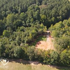Aerial view of a 2.5-acre wooded homesite in Campobello, showcasing cleared land surrounded by lush greenery.