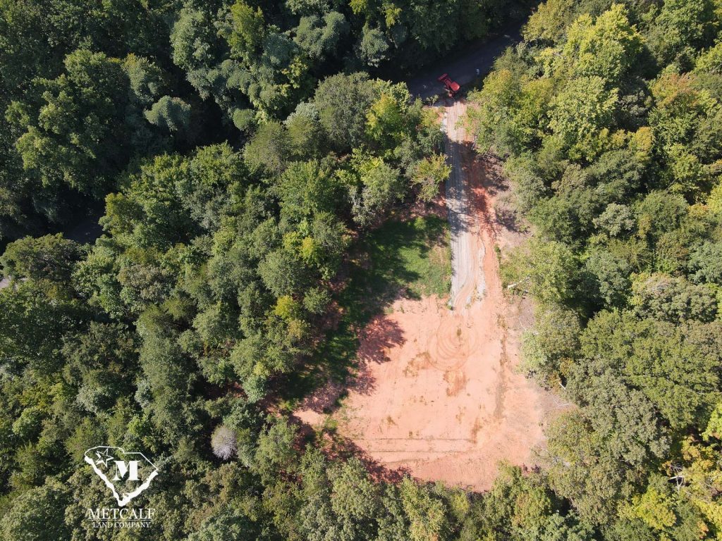 Aerial view of a cleared 2.5-acre homesite surrounded by lush trees in Campobello, ready for development.