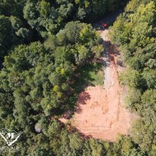 Aerial view of a cleared 2.5-acre homesite surrounded by lush trees in Campobello, ready for development.