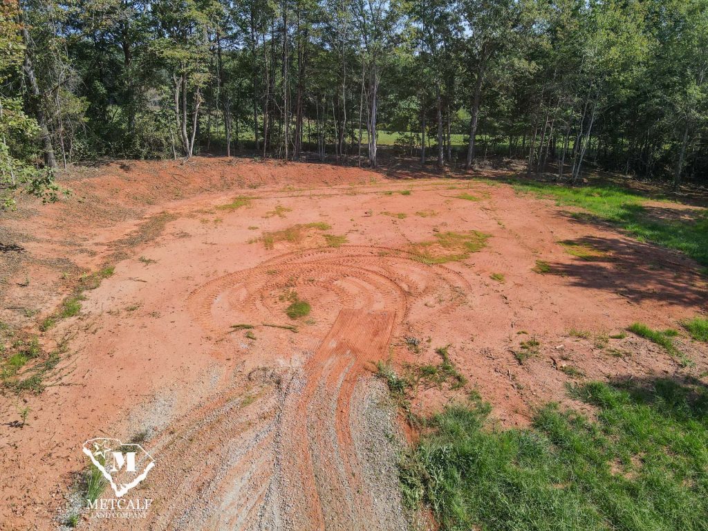 Cleared 2.5-acre homesite in Campobello, surrounded by trees and featuring a dirt path.