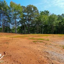 Cleared 2.5-acre homesite in Campobello, surrounded by trees and blue sky, ready for development.
